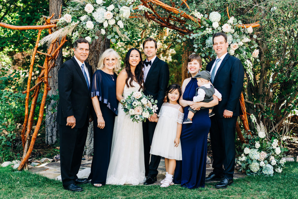 family photo in front of wooden arch at gold mountain manor in big bear
