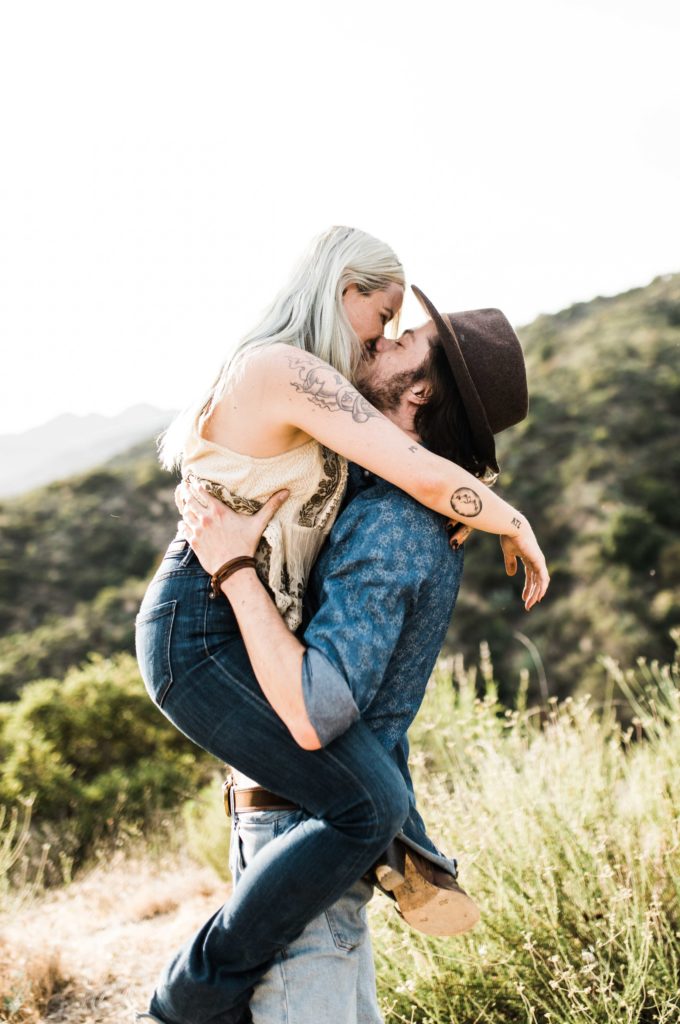 southern california engagement photos locations; man holding woman while they kiss