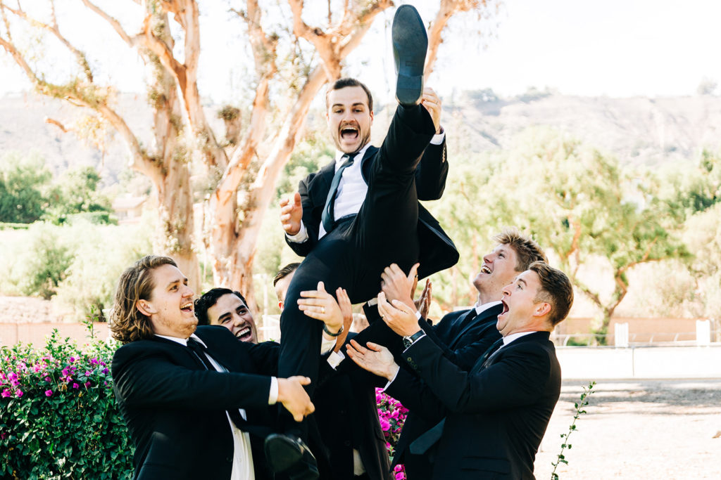 Camarillo wedding photography ; candid groomsmen toss the groom