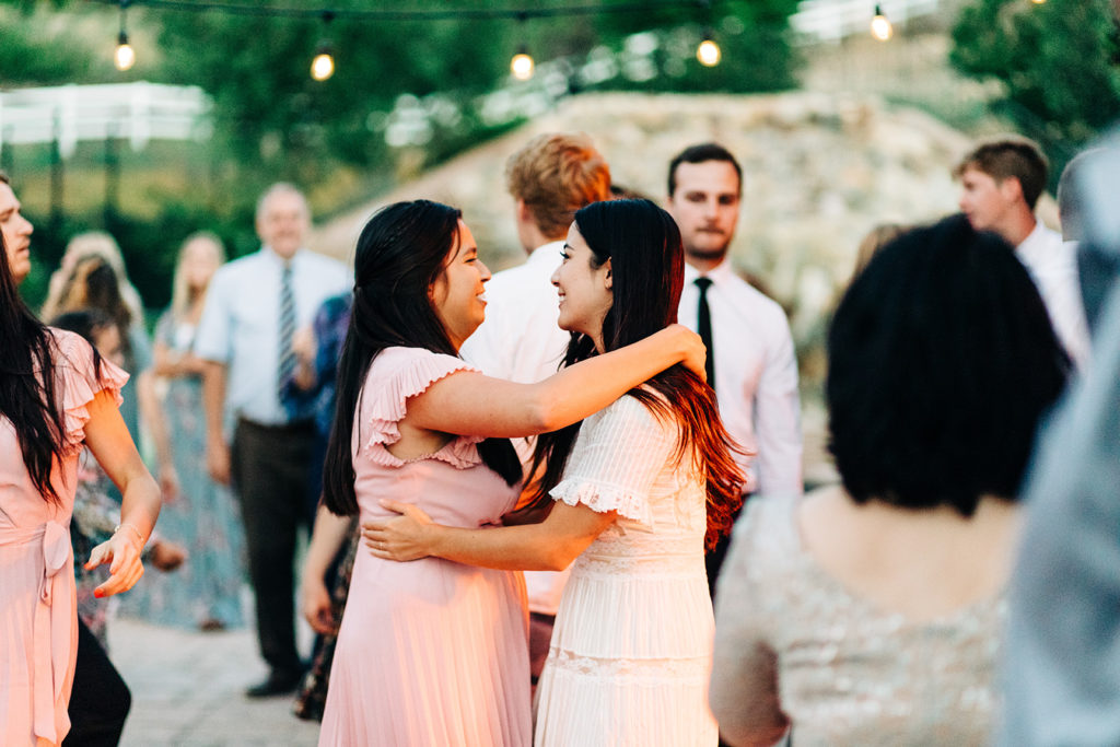 Camarillo wedding photography ; bride hugs bridesmaid at reception