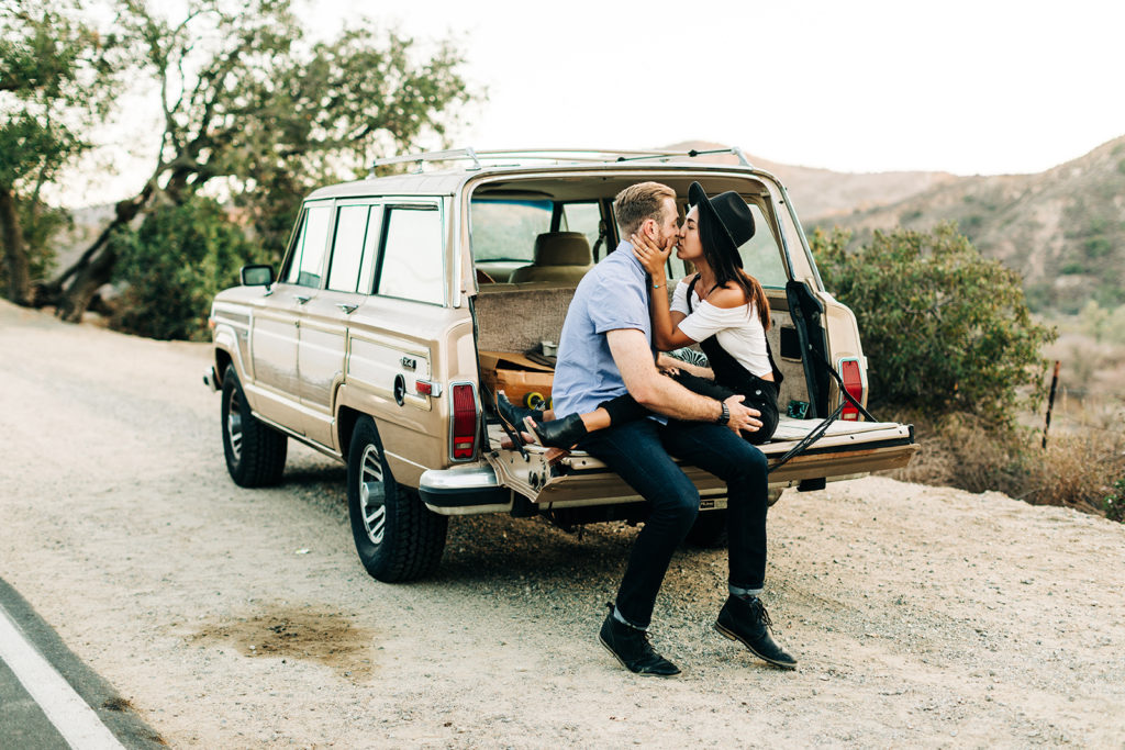 southern california engagement photos; couple kissing in trunk of jeep grand wagoneer