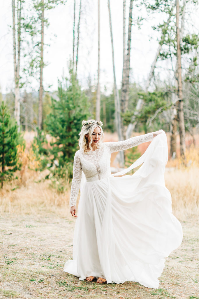Redfish Lake Lodge wedding photography ; bride tossing her wedding dress train in a field
