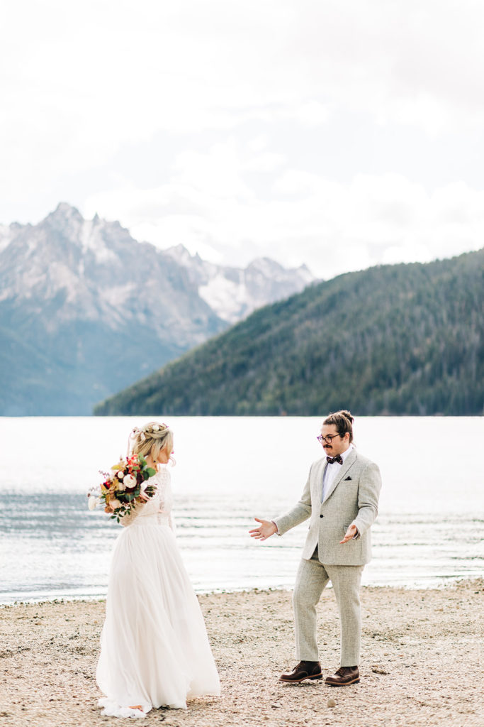 Redfish Lake Lodge wedding photography ; groom turns around and sees bride by a lake