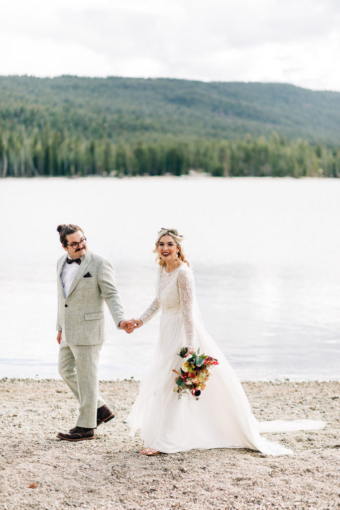 Redfish Lake Lodge wedding photography ; bride and groom hold hands and walk