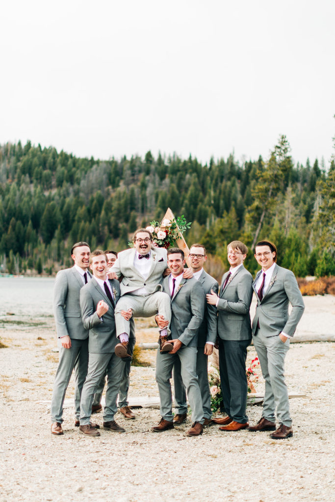 Redfish Lake Lodge wedding photography ; groomsmen lift up groom
