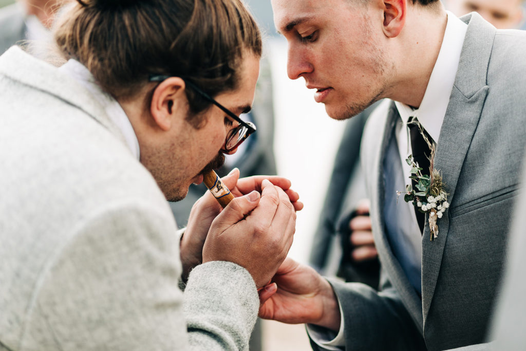 Redfish Lake Lodge wedding photography ; groom lights a cigar