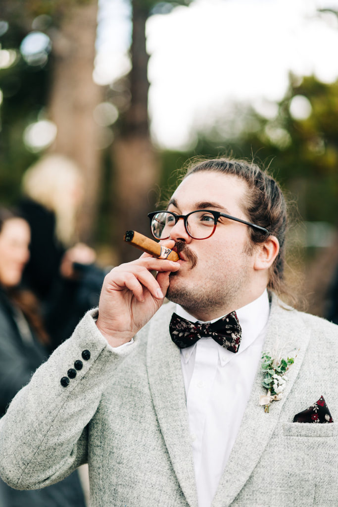 Redfish Lake Lodge wedding photography ; groom smokes a cigar