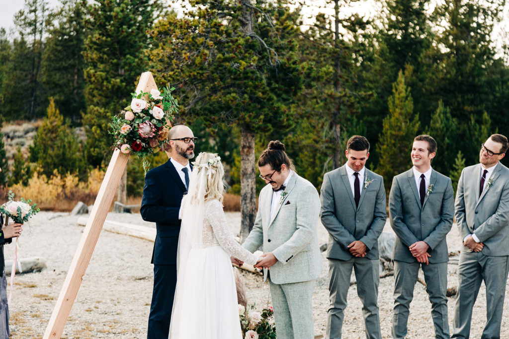 Redfish Lake Lodge wedding photography ; groom smiles at the ground during ceremony