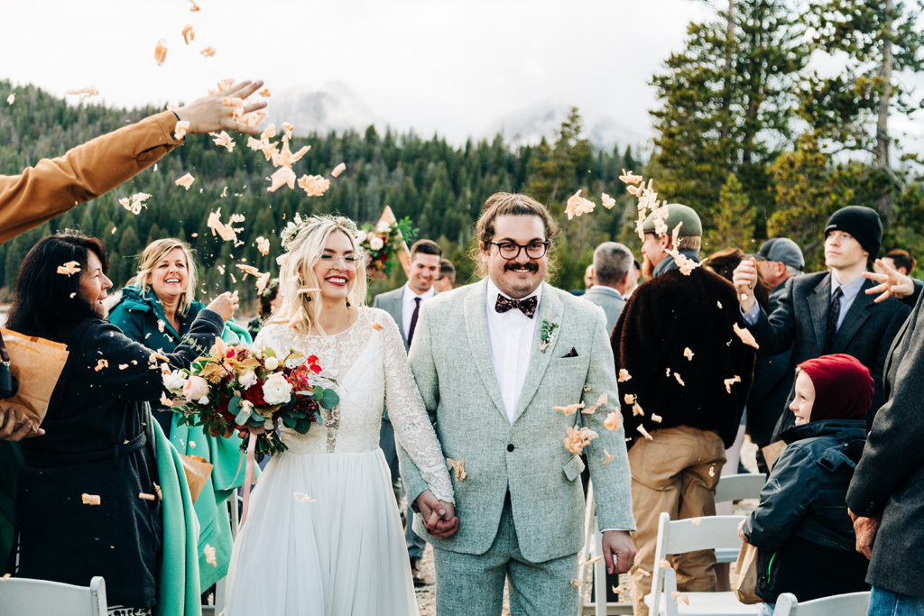 Redfish Lake Lodge wedding photography ; guests throw flower petals on the couple