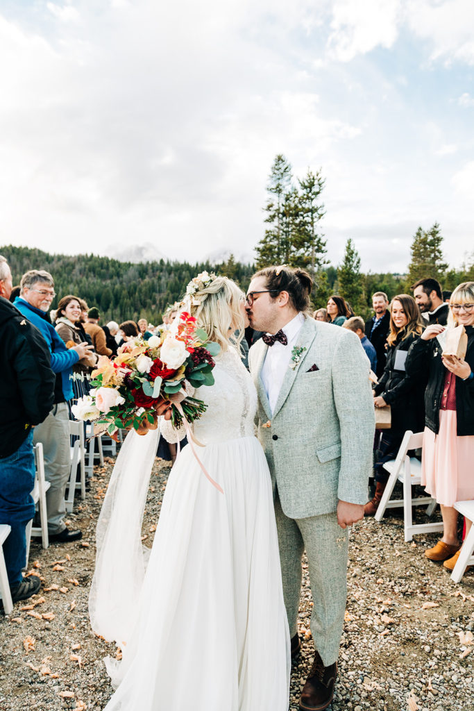 Redfish Lake Lodge wedding photography ; bride and groom kiss at the end of the aisle
