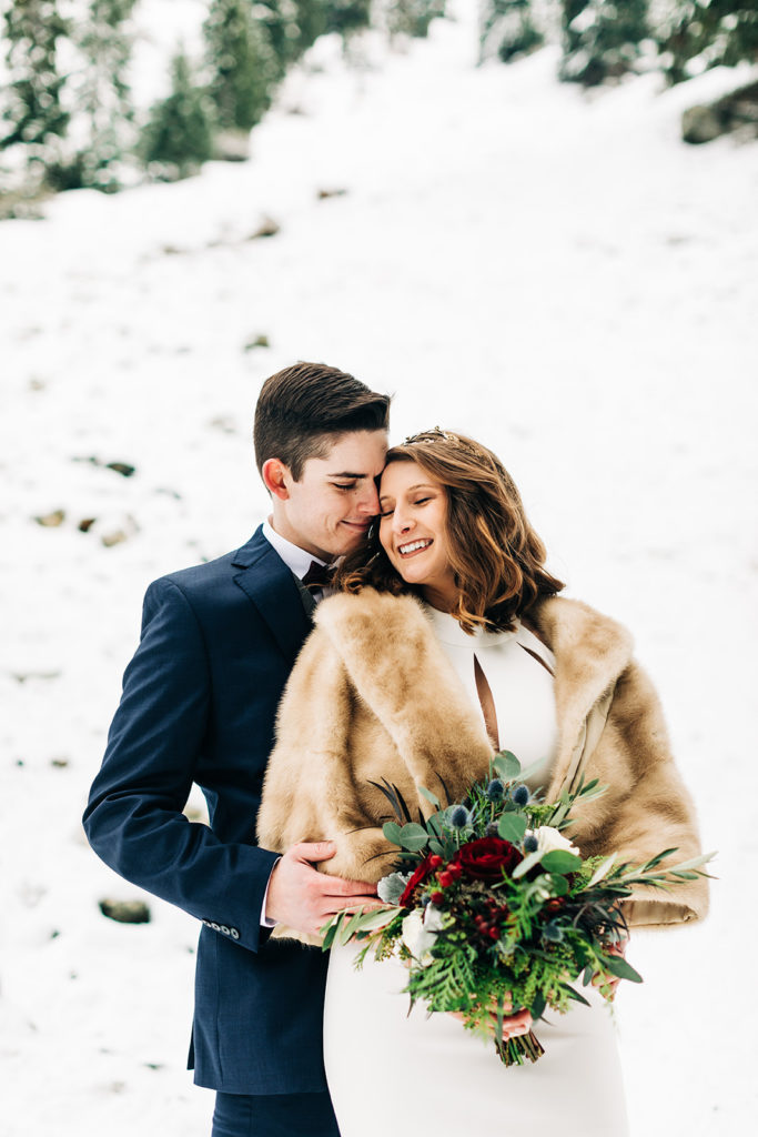 Mt. Baldy wedding photography ; bride and groom post with bouquet in furry jacket