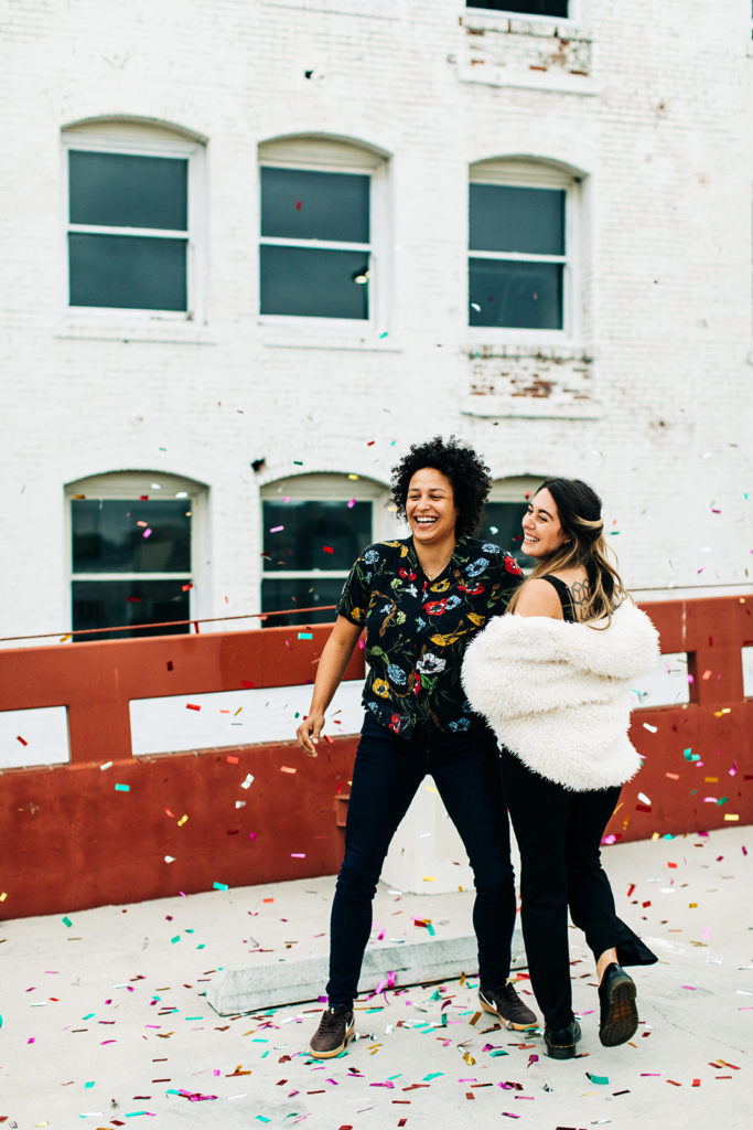 southern california engagement photos; lesbian couple surrounded by falling confetti
