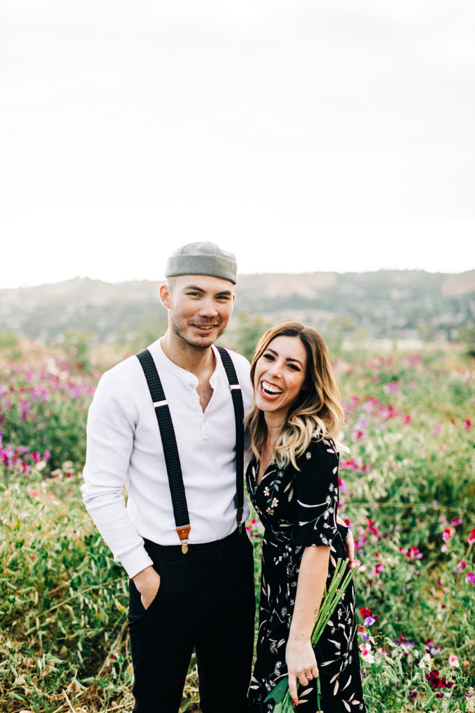 orange county engagement photos; couple laughing in a field of flowers