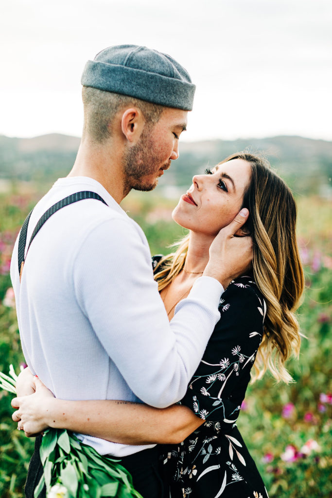 orange county engagement photos; man holding woman's face lovingly while she looks at him