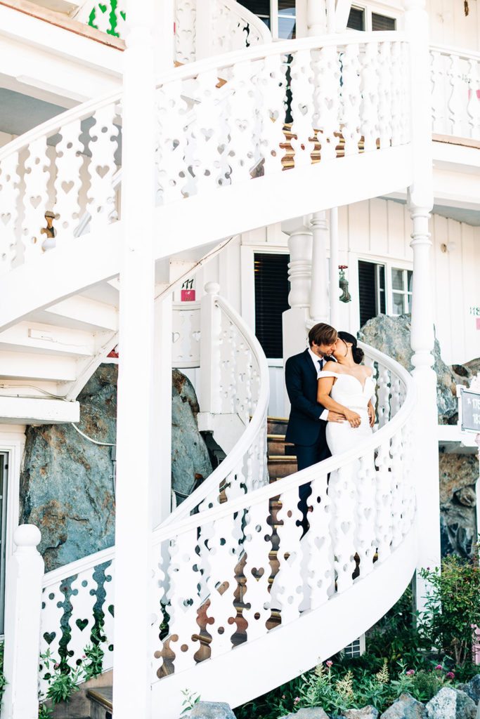 The Madonna Inn In San Luis Obispo, CA wedding photography; bride and groom kissing on the stairs