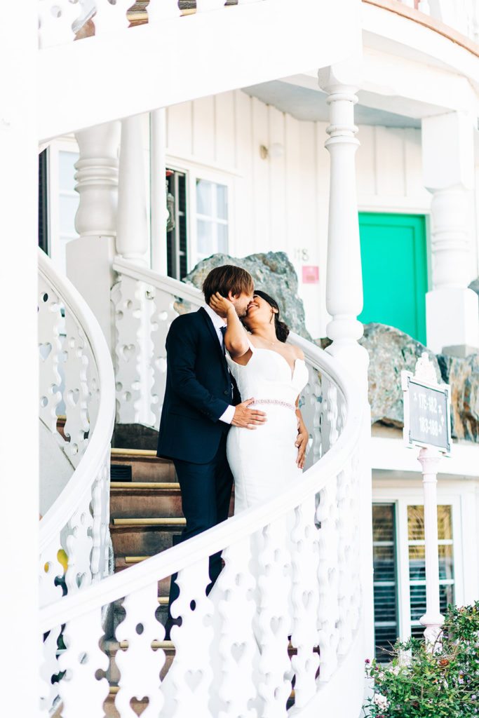 The Madonna Inn In San Luis Obispo, CA wedding photography; bride and groom kissing on the stairs