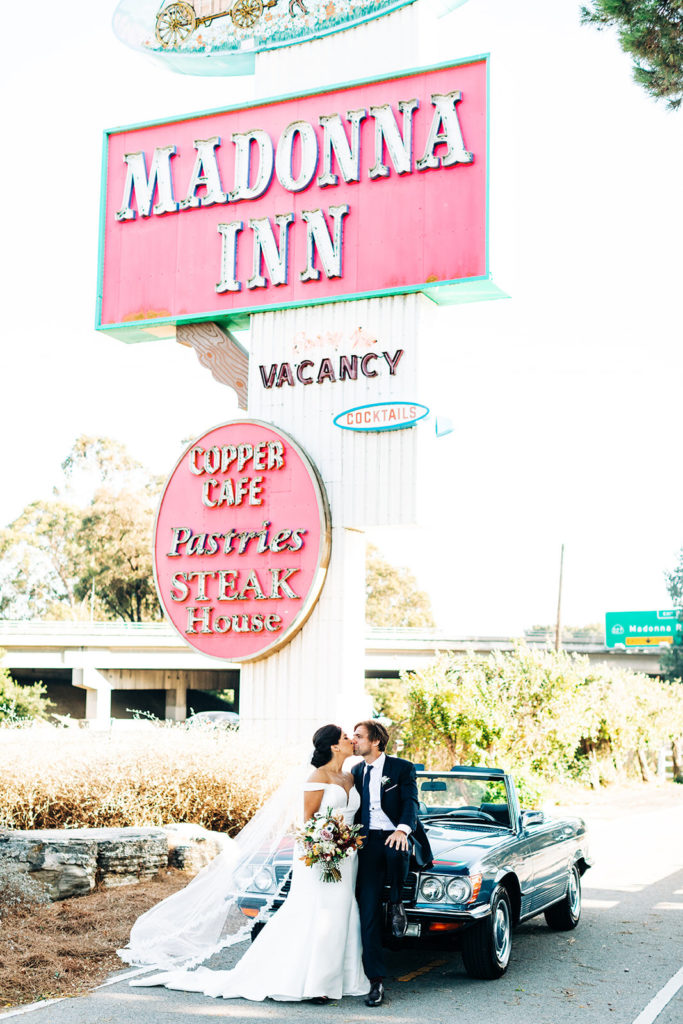 The Madonna Inn In San Luis Obispo, CA wedding photography; bride and groom kissing each other in front of a cafe
