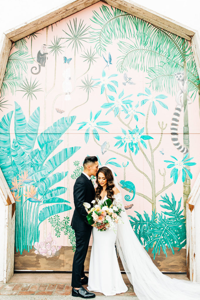 bride and groom in front of a mural at Valentine DTLA wedding venue