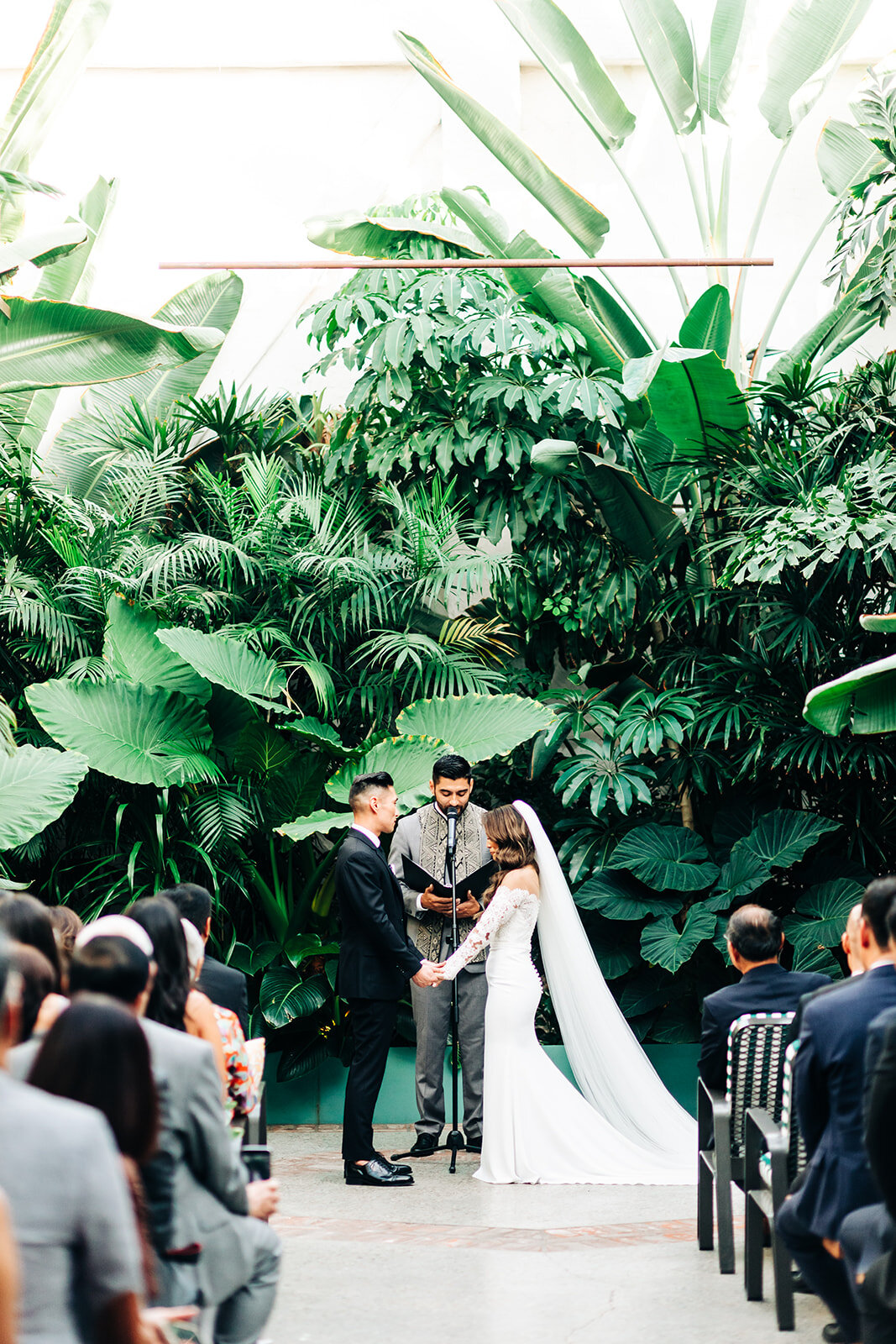 bride and groom saying their vows in front of foliage at Valentine DTLA wedding venue