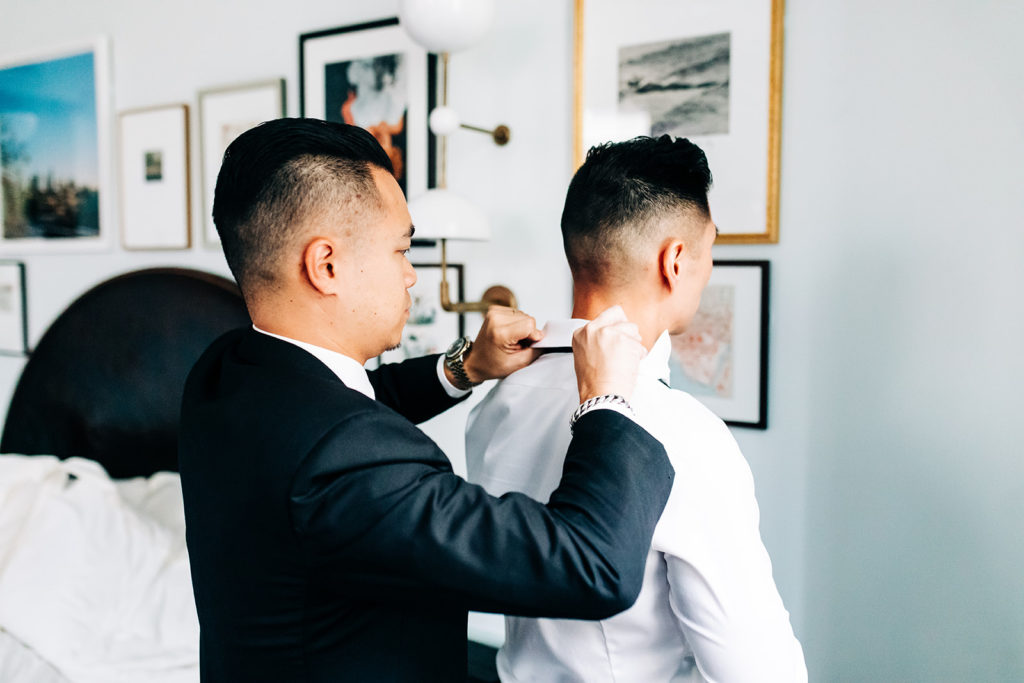 Valentine DTLA Wedding photographer; groomsmen helping groom put on his tie
