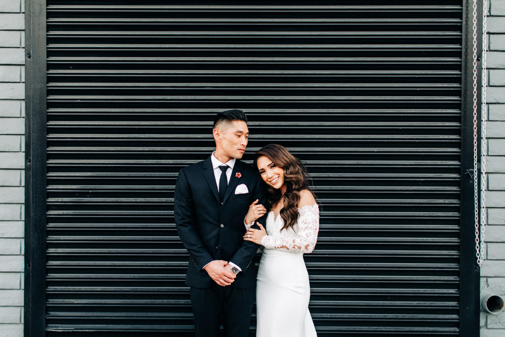 Valentine DTLA Wedding, Los Angeles wedding photographer; bride and groom holding each other in front of a black garage door