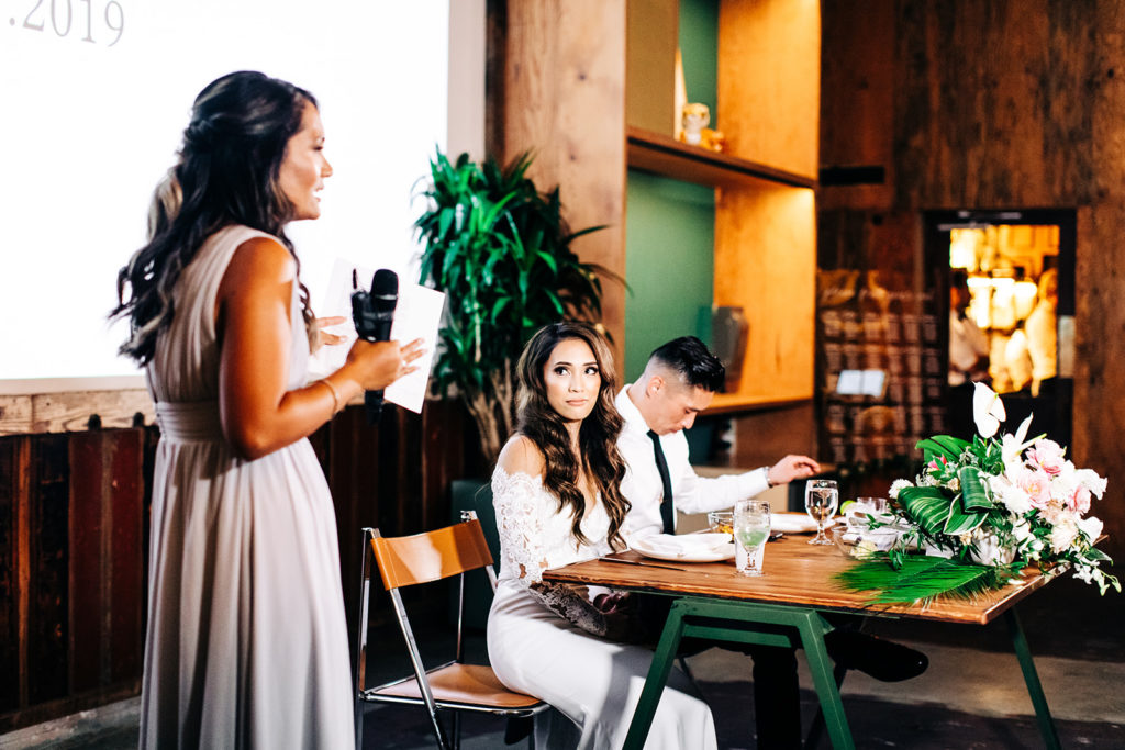 Valentine DTLA Wedding, Los Angeles wedding photographer; bride looking at her bridesmaid reading a speech during the reception