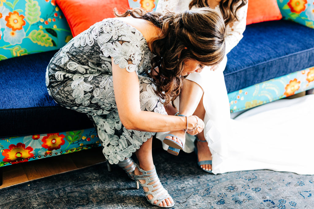 Valentine DTLA Wedding, Los Angeles wedding photographer; mother of the bride helps the bride put her shoes on