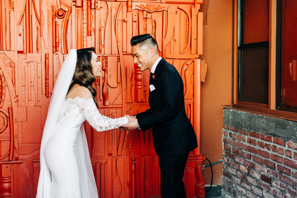 Valentine DTLA Wedding, Los Angeles wedding photographer; bride and groom laughing together holding hands