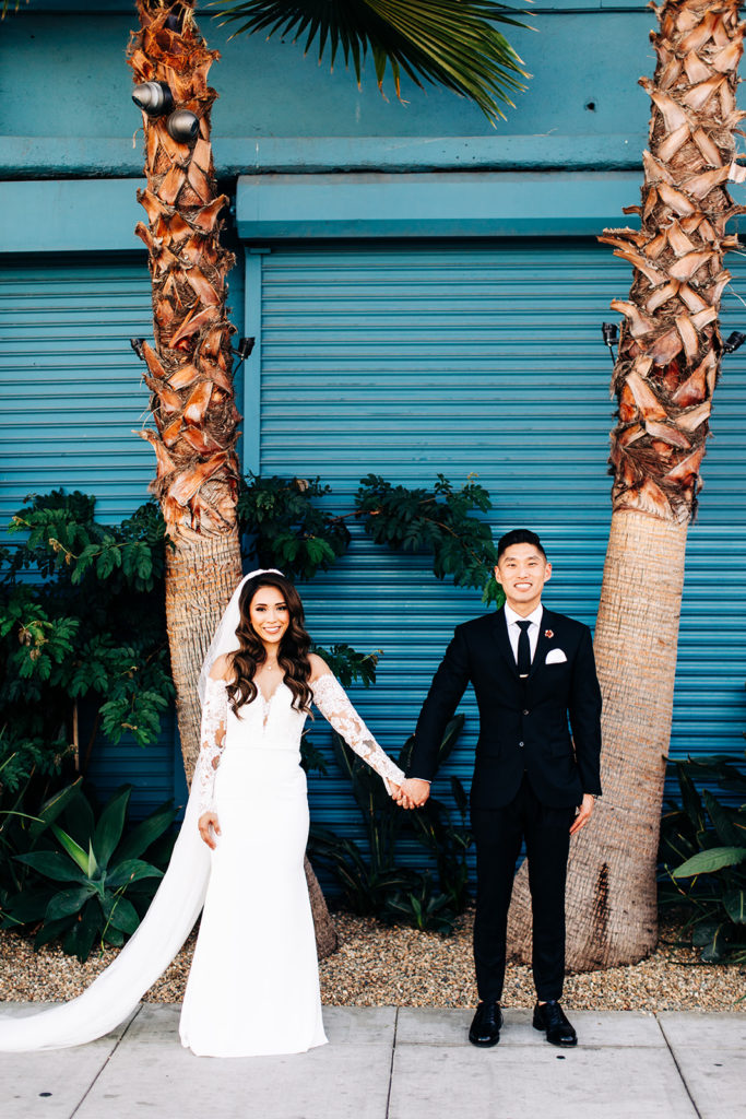Valentine DTLA Wedding, Los Angeles wedding photographer; bride and groom holding hands and smiling at the camera