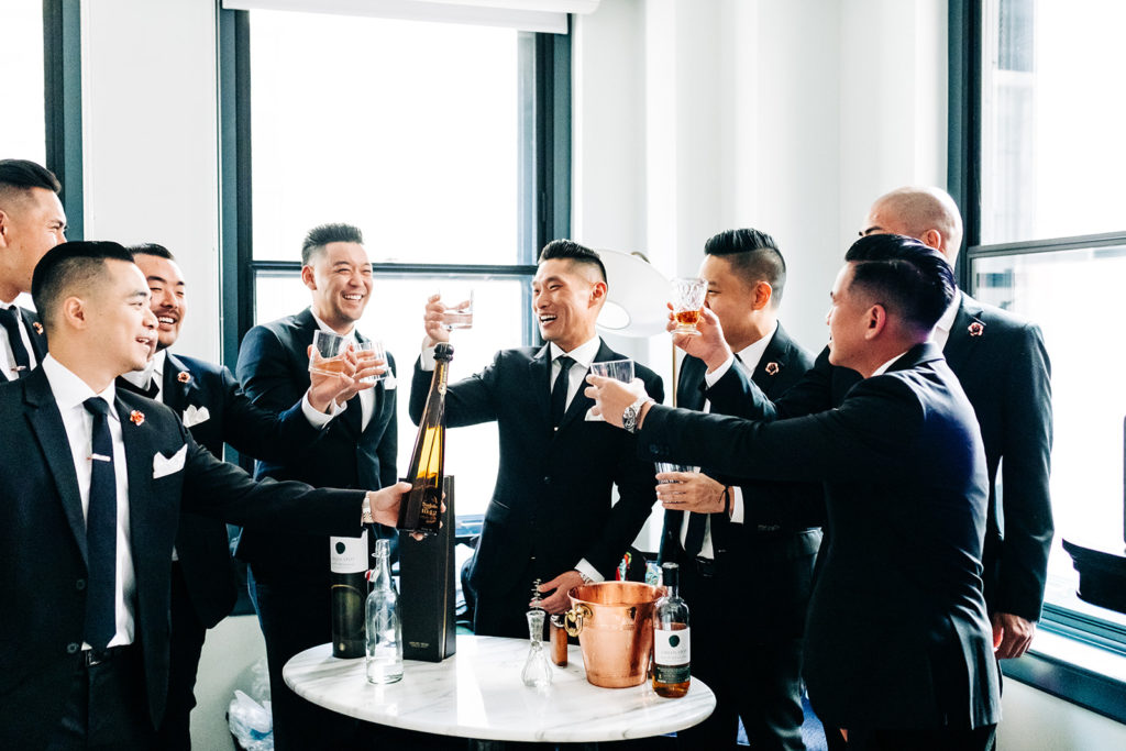 Valentine DTLA Wedding, Los Angeles wedding photographer; groomsmen holding their whiskey glasses up to cheers the groom