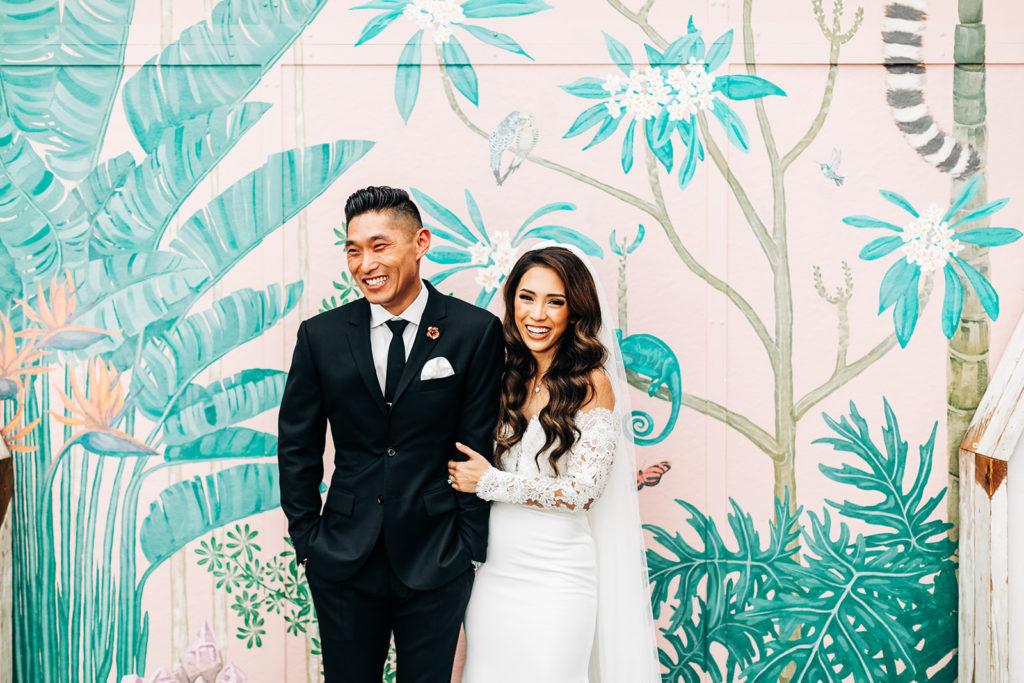 Valentine DTLA Wedding, Los Angeles wedding photographer; bride and groom holding each other and laughing in front of a colorful wall mural