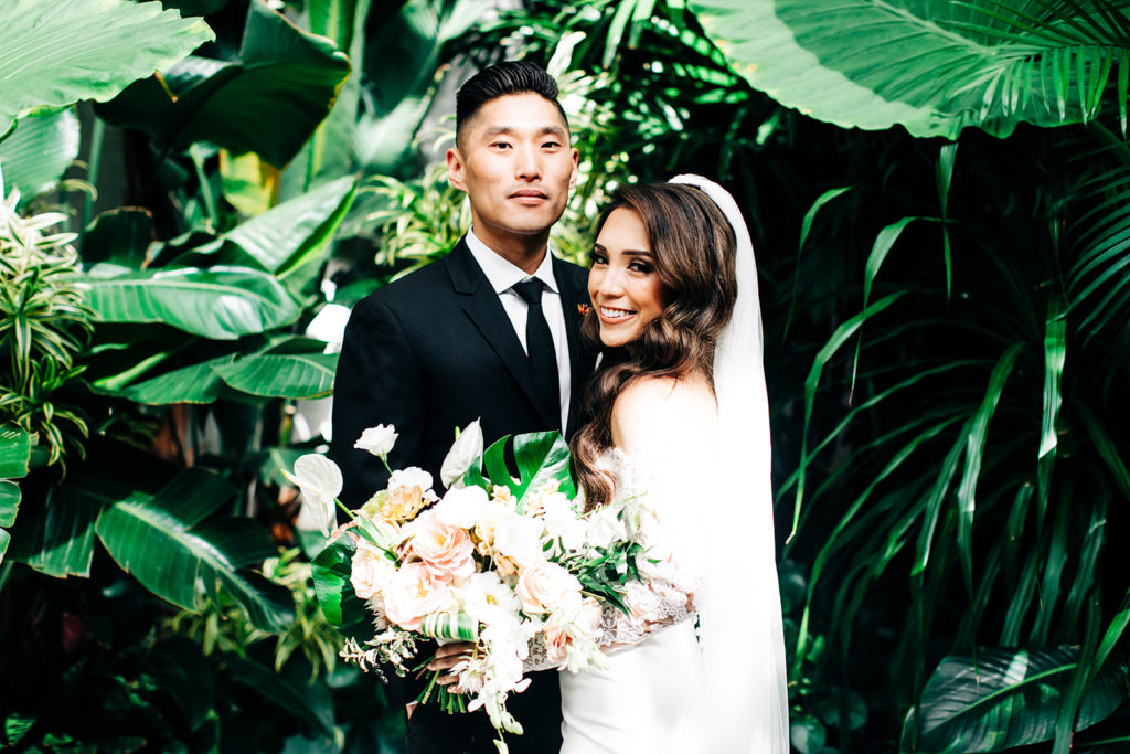 Valentine DTLA Wedding, Los Angeles wedding photographer; bride and groom smiling in front of a bunch of green plants