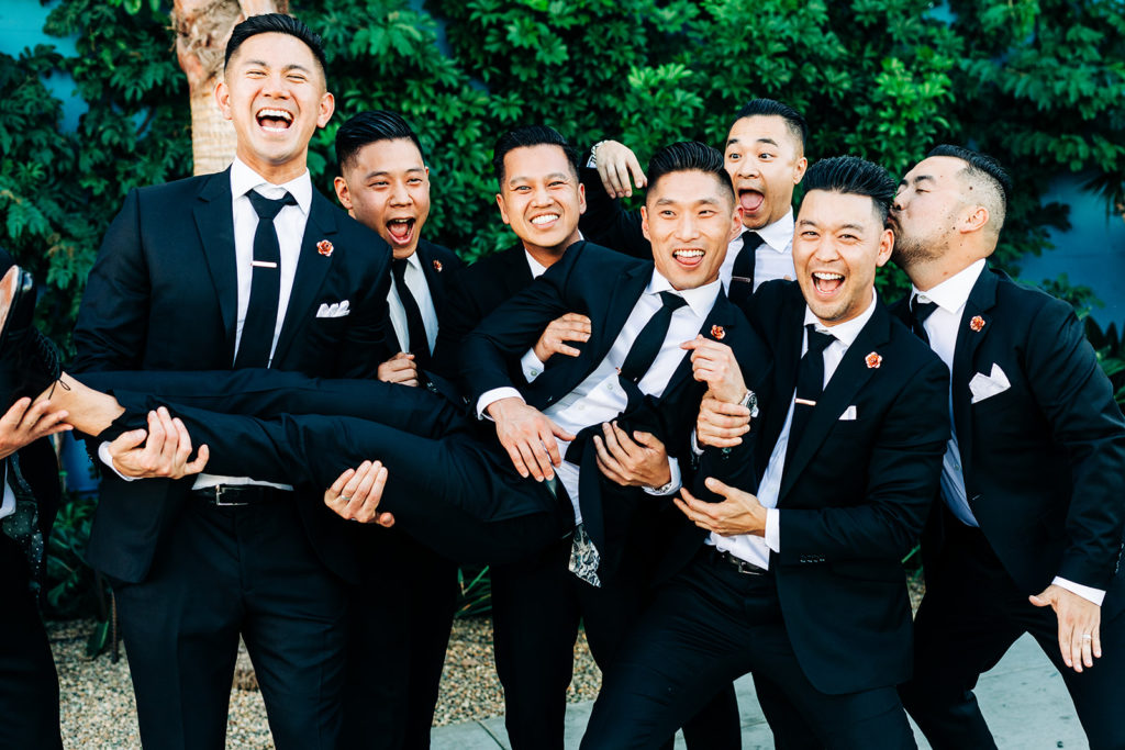 Valentine DTLA Wedding, Los Angeles wedding photographer; groomsmen picking up the groom on his wedding day and laughing