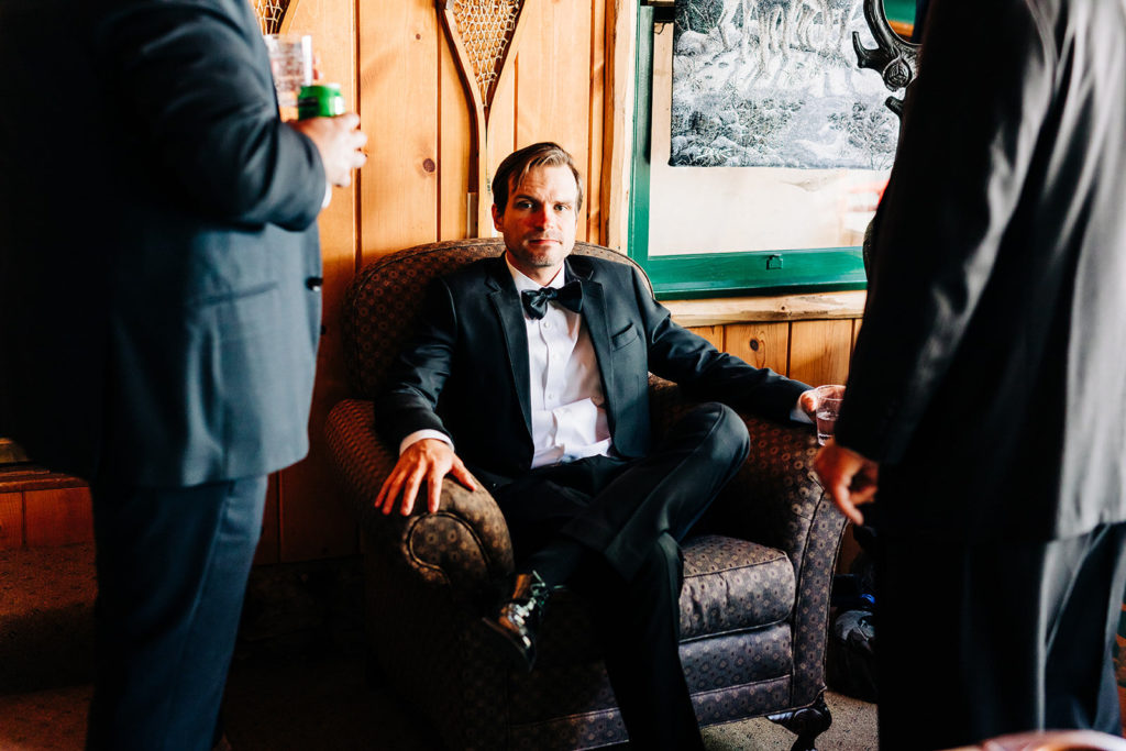 The Gold Mountain Manor In Big Bear, CA wedding photography; groom sitting on the sofa