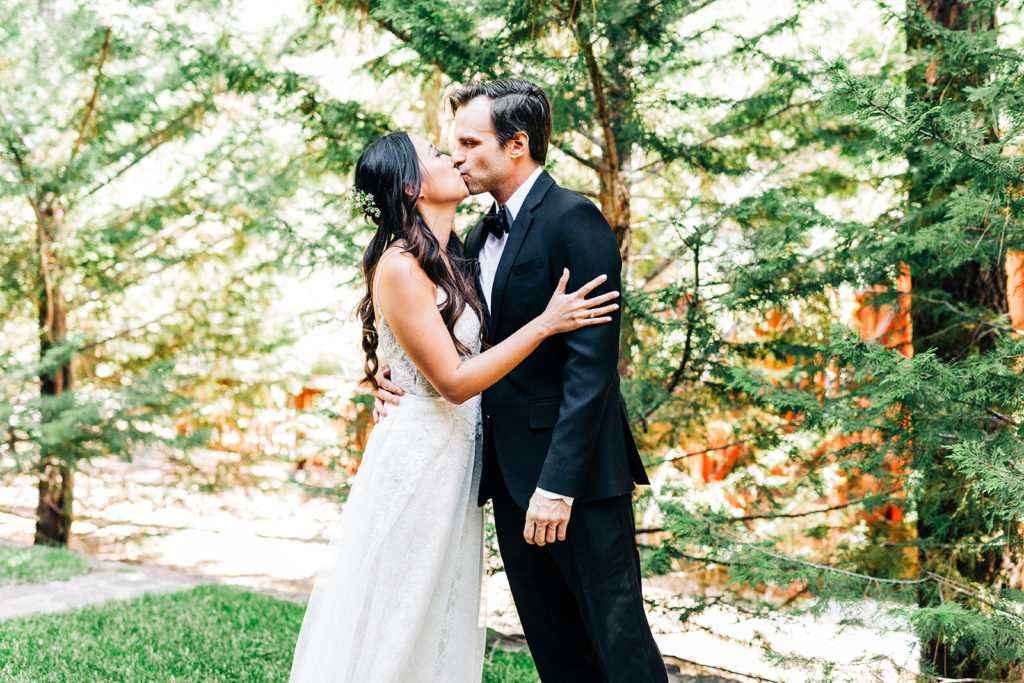The Gold Mountain Manor In Big Bear, CA wedding photography; a kiss between bride and groom