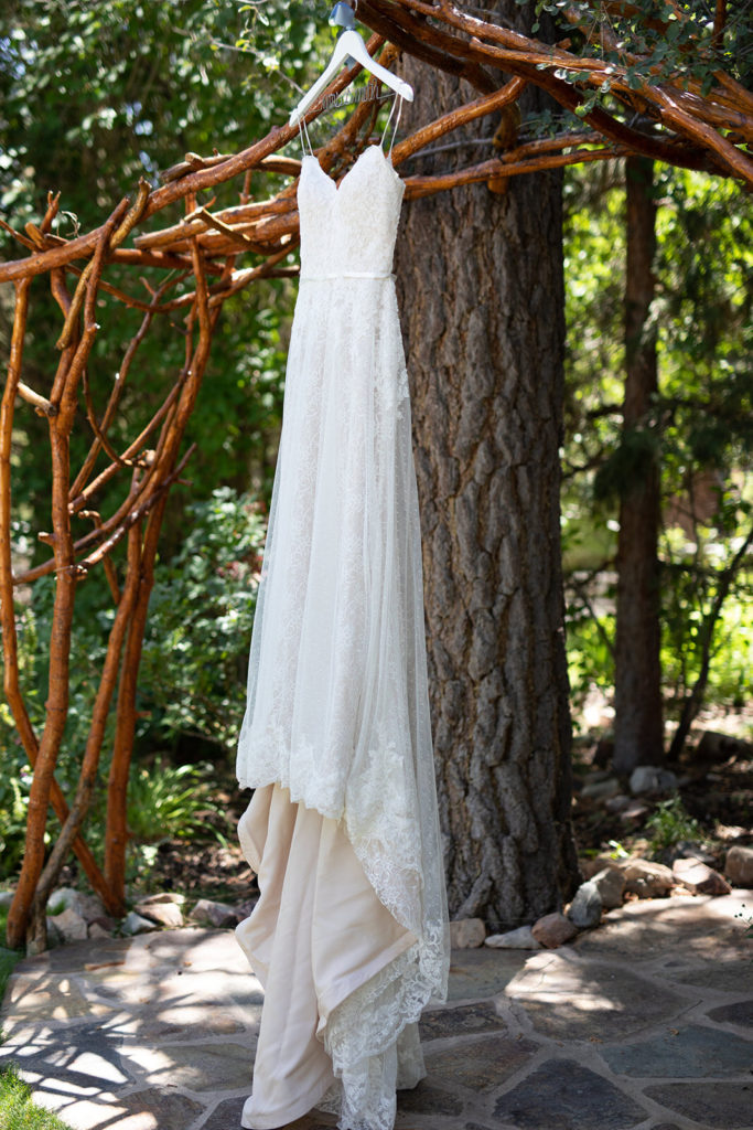 The Gold Mountain Manor In Big Bear, CA wedding photography; bridal dress hangin on the wooden arches
