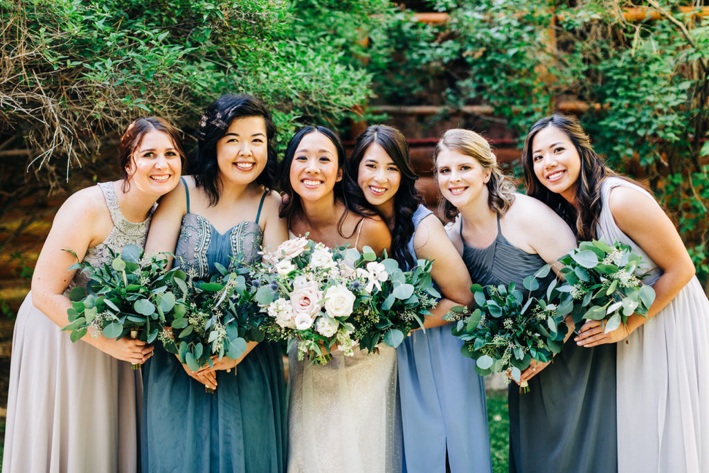 The Gold Mountain Manor In Big Bear, CA wedding photography; bride with bridesmaids in front of green trees