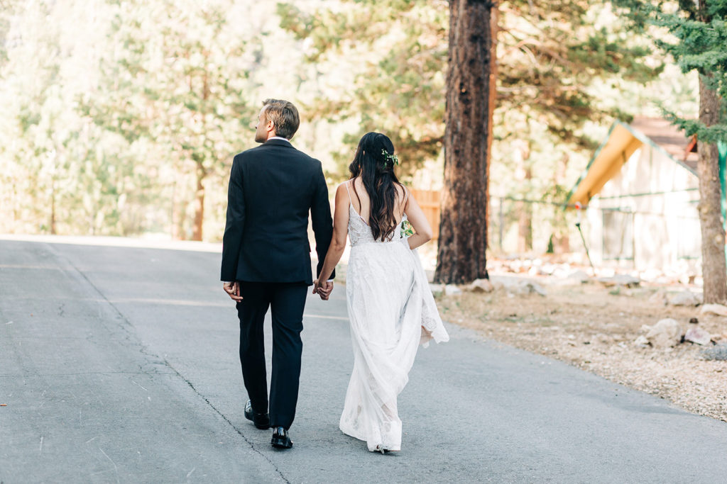 The Gold Mountain Manor In Big Bear, CA wedding photography; bride and groom walking on the uphill road