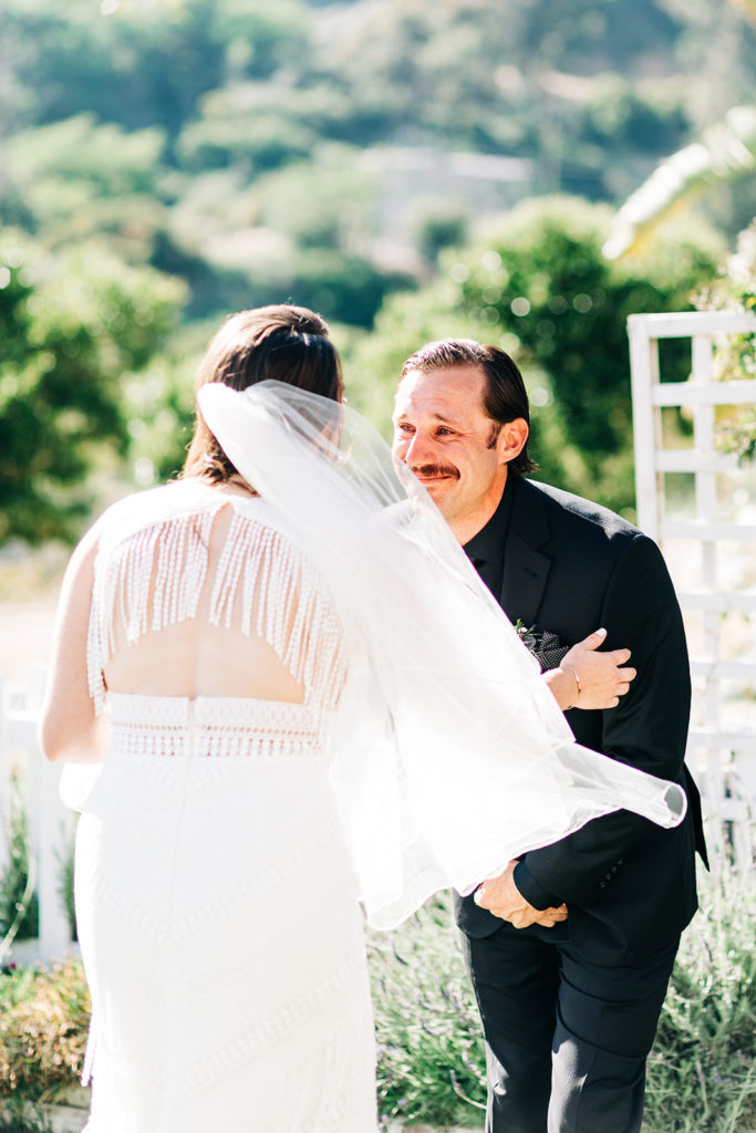 Sweet Pea Ranch In Upland, CA wedding photography; groom looking at her bride while standing obediently