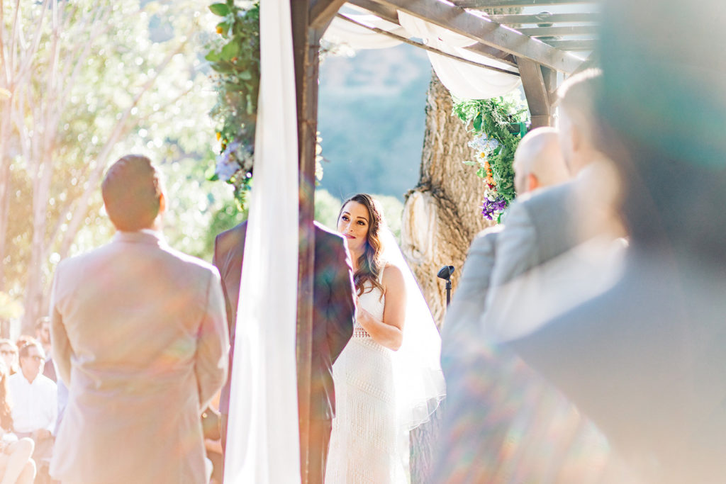 Sweet Pea Ranch In Upland, CA wedding photography; bride and groom photograph from behind the wooden pillar