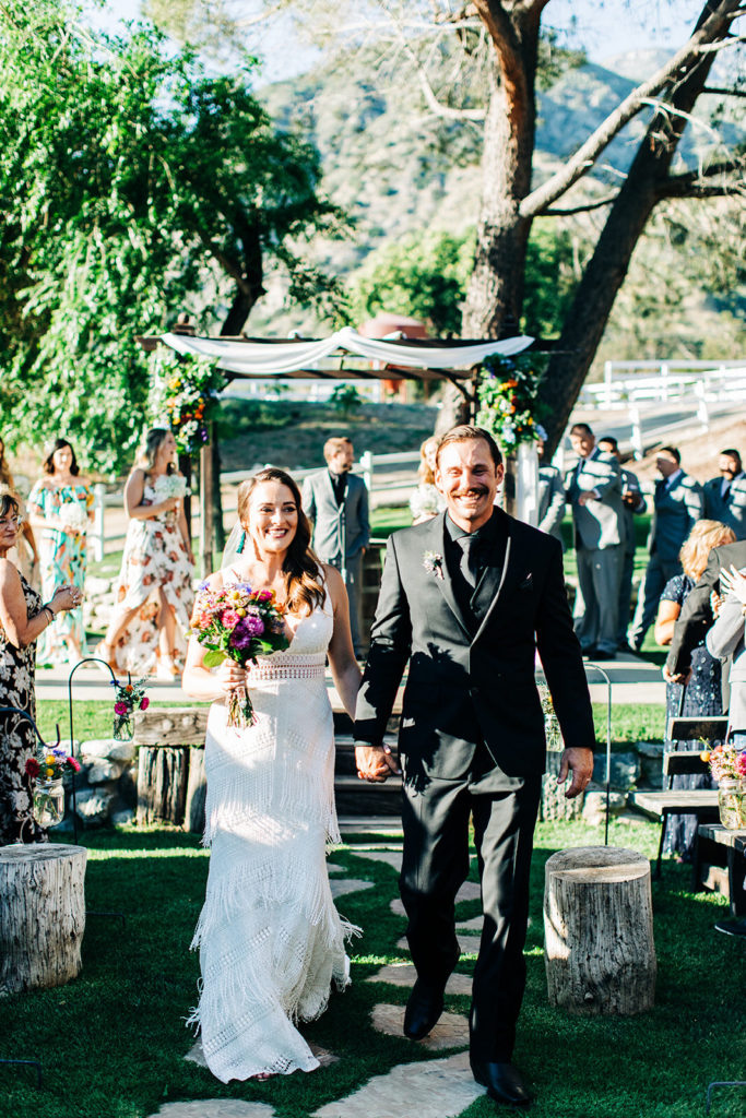 Sweet Pea Ranch In Upland, CA wedding photography; bride and groom walking on the path while smiling