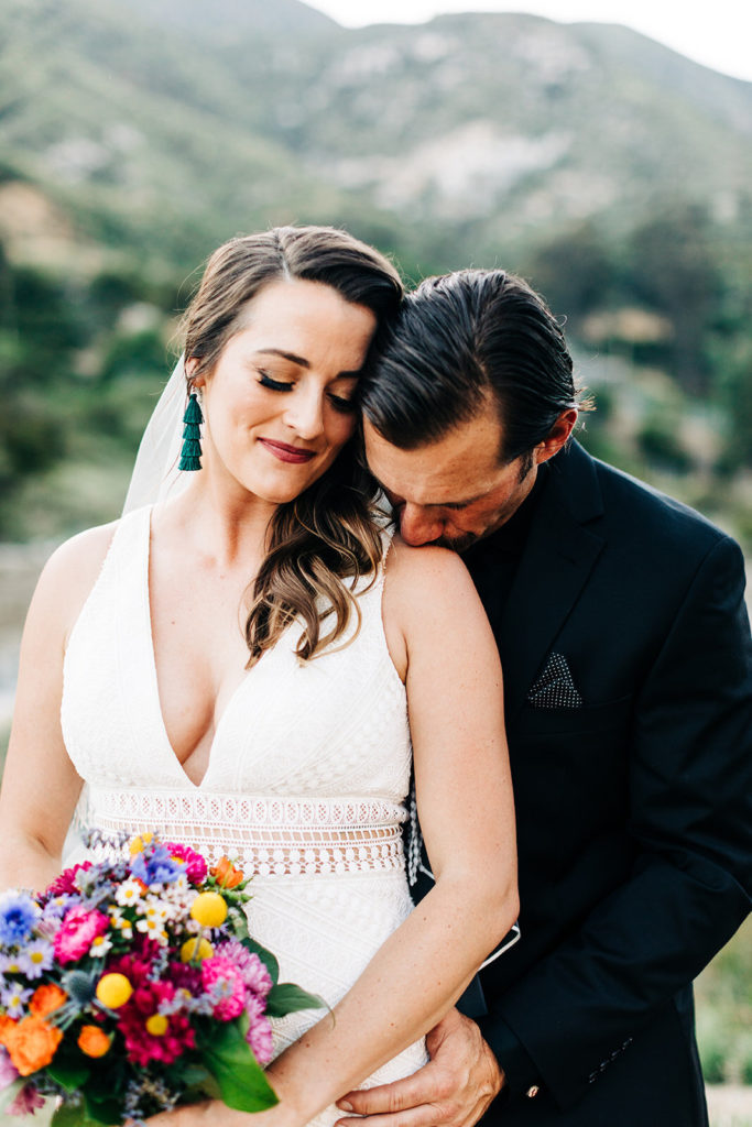 Sweet Pea Ranch In Upland, CA wedding photography; groom kissing bride's shoulder