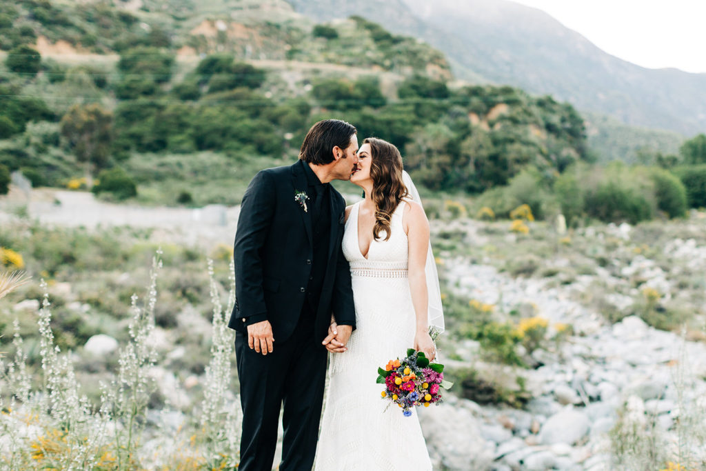 Sweet Pea Ranch In Upland, CA wedding photography; bride and groom kissing on hill