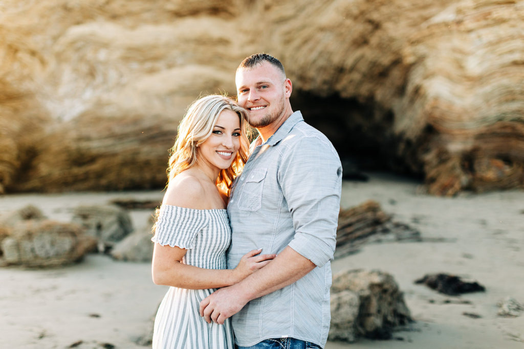 crystal cove beach engagement photos in orange county; couple hugging and smiling at the beach