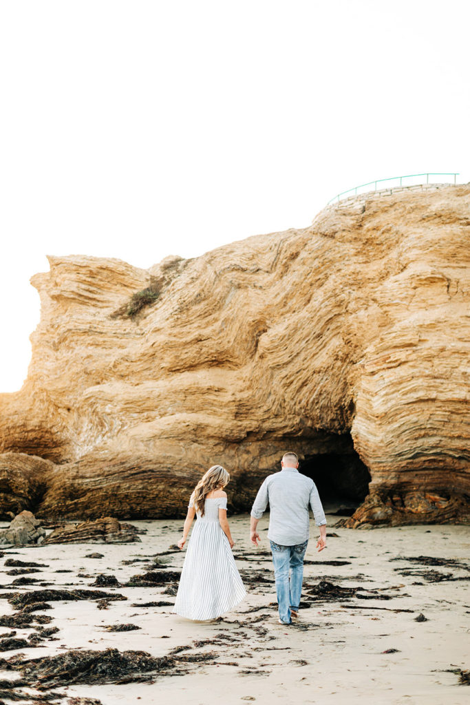 crystal cove beach engagement photos in orange county; couple walking on the beach