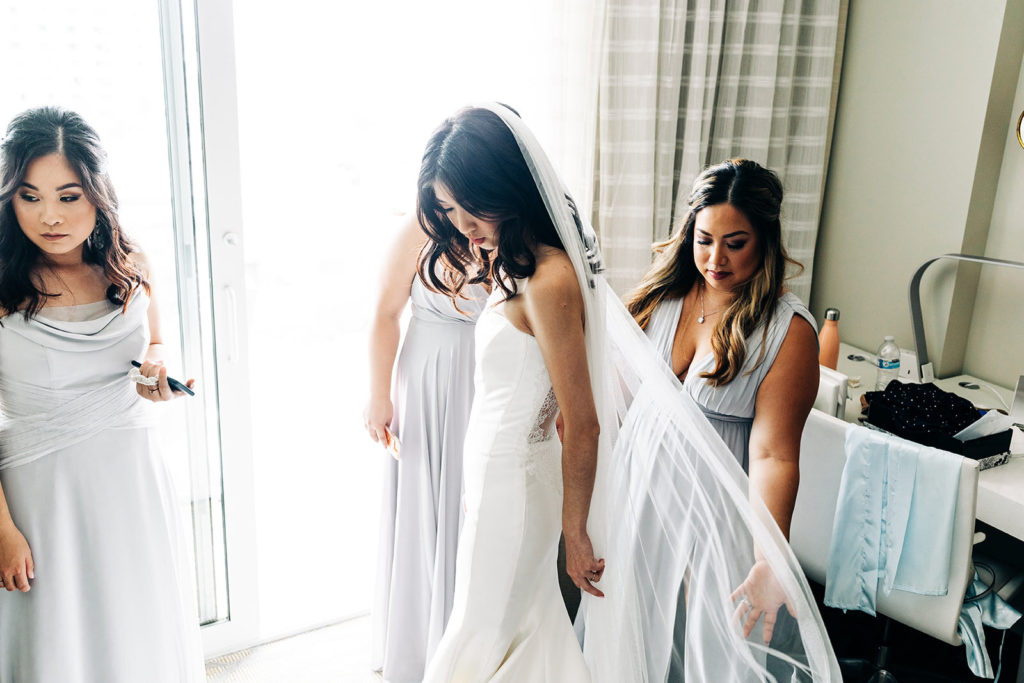 Pasea Hotel & Spa in Huntington Beach, CA wedding photography; bride checking her bridal dress after wearing