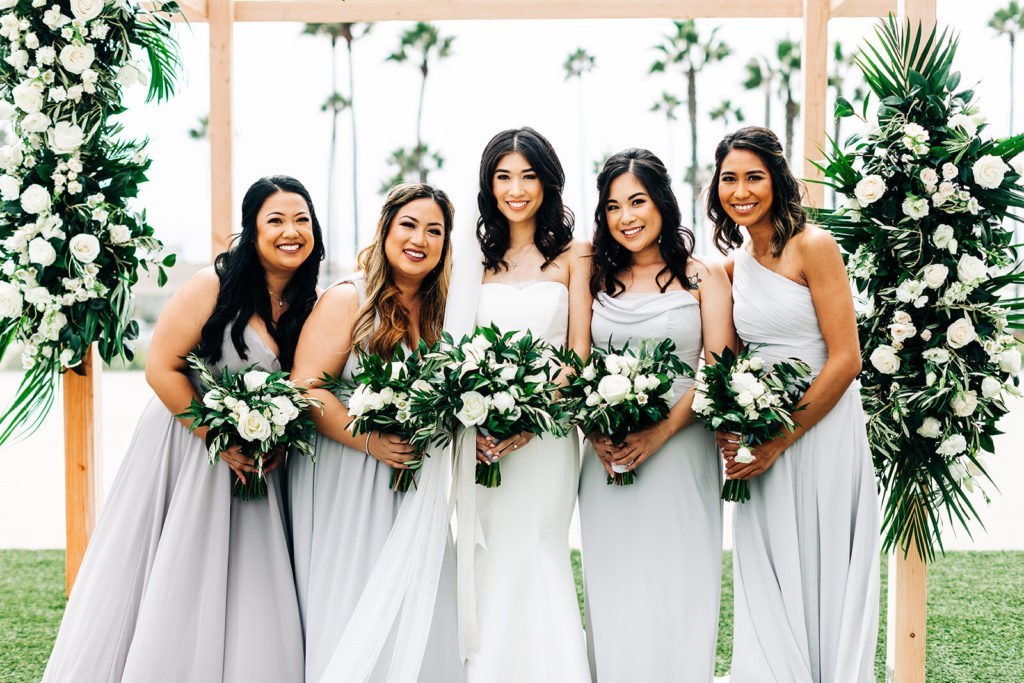 Pasea Hotel & Spa in Huntington Beach, CA wedding photography; bride with bridesmaids with beautiful flowers in hands with a lovely background