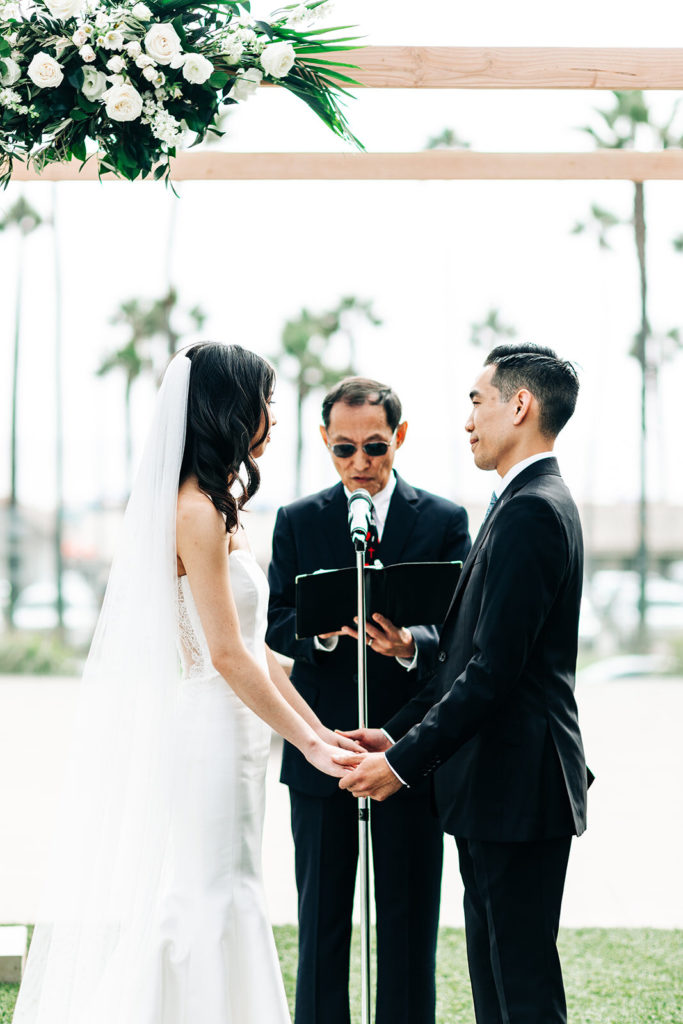 Pasea Hotel & Spa in Huntington Beach, CA wedding photography; bride and groom holding each other's hands before reading vows