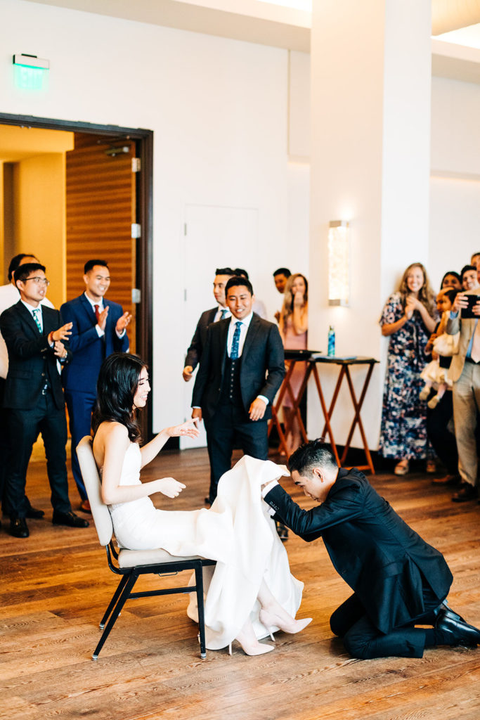 Pasea Hotel & Spa in Huntington Beach, CA wedding photography; groom removing the garter from bride's leg