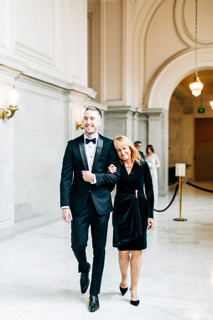 City Hall in San Francisco, CA wedding photography; groom and his mom coming